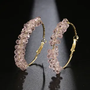 Vue rapprochée et détaillée des créoles étincelantes en perles de cristal rose et or.