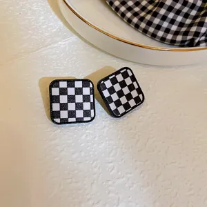 Classic black and white checkerboard square earrings, retro geometric design detail view.