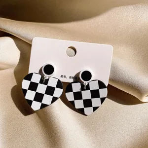Black and white checkerboard heart earrings, retro geometric contrast color design jewelry.