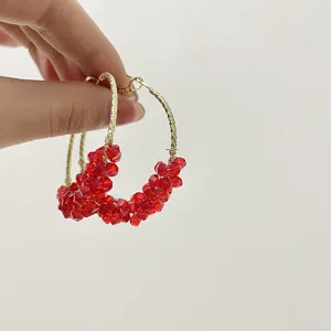 Vue detaillee de creoles en or avec perles de cristal rouge pour femmes elegantes.