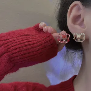 Detailed close-up of cute hollow rhinestone tiger earrings worn on ear, sparkling design.