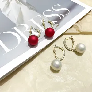Trendy C-shape hoop earrings featuring red and white pearl drops for stylish women's wear.