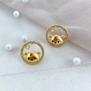 Close-up detail of cute zodiac tiger earrings with sparkling rhinestones and gold finish.