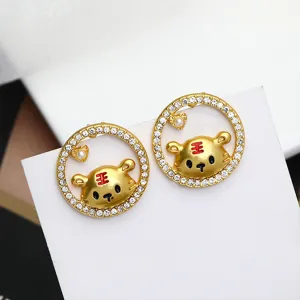 Close-up detail shot of cute tiger stud earrings with sparkling rhinestones and red accents.