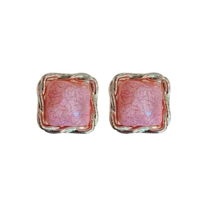 Elegante quadratische Damen Ohrringe mit goldenem Twist-Rand und rosa strukturierter Mitte.