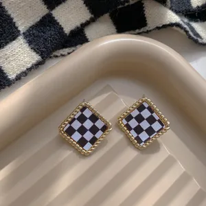 Exquisite black and white checkered rhombus earrings featuring a stylish twisted gold border design.