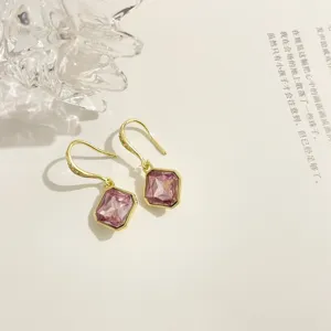 Detailaufnahme von eleganten quadratischen pinken Kristall-Ohrhängern in Goldoptik.