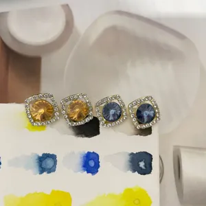 Vue rapprochée détaillée de boucles d'oreilles carrées en strass et cristaux ronds.