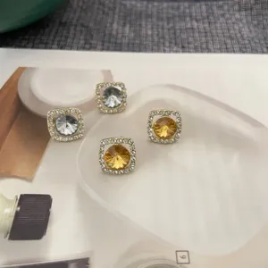Boucles d'oreilles carrées en cristal avec zircon étincelant et clous métalliques. Style élégant.