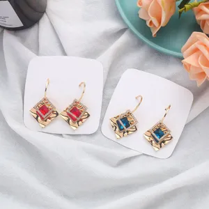 Detailed close-up of geometric square crystal earrings with rhinestones on white cards.