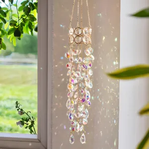 Nahaufnahme von hängendem Kristall-Sonnenfänger am Fenster mit bunten Regenbogen-Lichtreflexen.