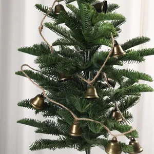Detailed shot of vintage metal bells string on jute rope for Christmas tree decor and home charm.