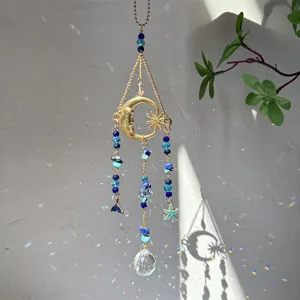 Crystal suncatcher pendant detail featuring blue beads, gold crescent moon and rainbow light.