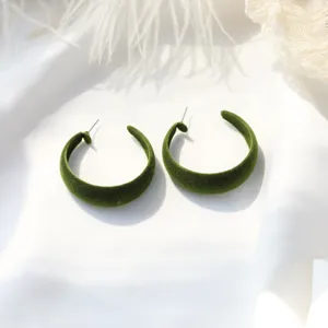 Green velvet hoop earrings detailed view, showing soft texture and elegant design.