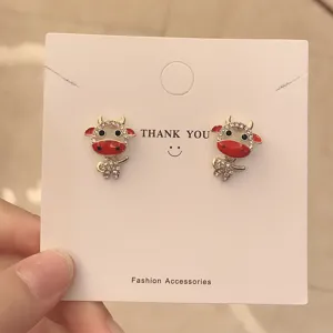 Graziosi orecchini a lobo toro con strass brillanti e finitura in smalto rosso elegante.