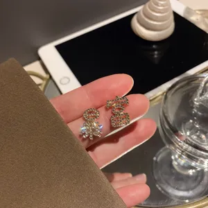 Gedetailleerd shot van trendy asymmetrische strass oorbellen met karakters, elegante modejuwelen.