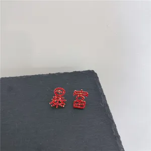 Chique asymmetrische rode strass oorknopjes met trendy Chinees karakterontwerp.