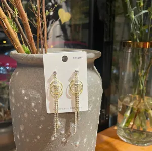 Detail view of stylish multi-ring geometric rhinestone tassel earrings with 925 silver needles.