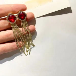 Longues boucles d'oreilles à franges de cristal rouge, bijoux élégants en strass doré chic.