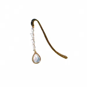 Metal bookmark detail showing the vintage carved hook, crystal beads, and teardrop pendant.