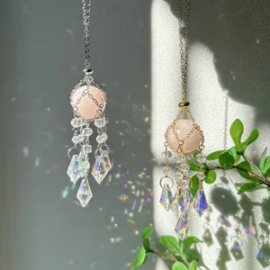 Crystal suncatcher detail view featuring faceted glass pendants and pink stone spheres reflecting light.