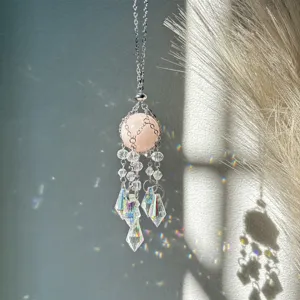 Crystal suncatcher hanging ornament with natural pink stone and rainbow light prism pendant.
