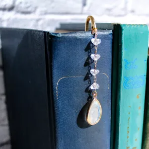 Metal bookmark with crystal pendant and bead chain, perfect for graduation gifts.