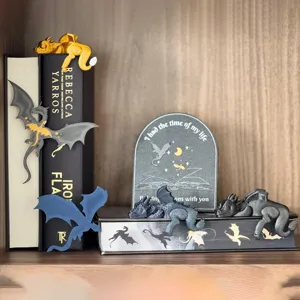 Detailed view of resin sleeping dragon figurines and flying dragons displayed on bookshelf.