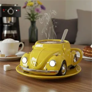 Yellow beetle shaped ceramic coffee cup detail shot with matching saucer and spoon on table.