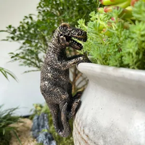 Gros plan d'un support de pot de fleurs dinosaure T-Rex en résine pour déco de jardin.