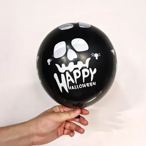 Gros plan d'un ballon en latex noir d'Halloween avec un imprimé effrayant de crâne et d'araignée.