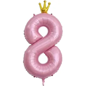 Gros plan ballon aluminium chiffre 8 rose avec couronne or pour decoration fete.