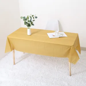 Nappe jetable dorée vue de détail lifestyle pour décor de fête, surface texturée lisse.