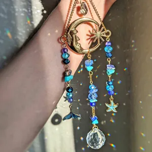 Crystal suncatcher detail showing rainbow refractions, blue beads, and crystal ball pendant.
