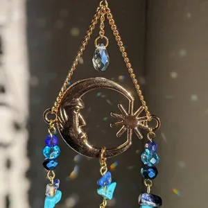 Crystal suncatcher hanging ornament with gold moon sun design blue beads and rainbow light effects