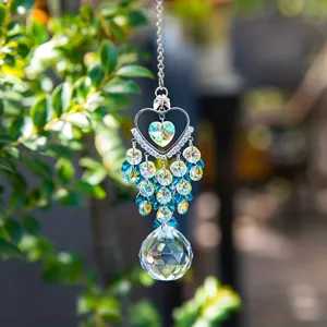 Close-up of sparkling heart crystal suncatcher prism hanging with vibrant blue beads.