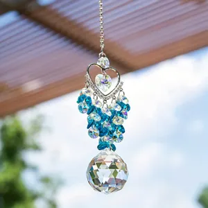 Hanging crystal suncatcher prism ball with heart frame and blue beads for window and garden decor.
