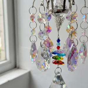 Detail shot of hanging crystal suncatcher with multi-faceted prismatic beads and rainbow reflections.