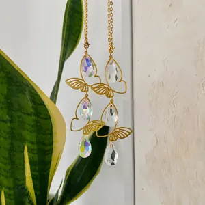 Detail shot of hanging golden butterfly crystal suncatcher with prismatic teardrop pendants.