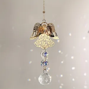 Nahaufnahme des goldenen Metallengels und geschliffener Kristallkugeln mit Lichteffekten.
