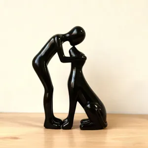 Close-up of black resin human and dog sculpture, modern art decor for desktop and home.