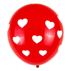 Gros plan du ballon en latex rouge avec des motifs de coeurs blancs, parfait pour les fêtes.