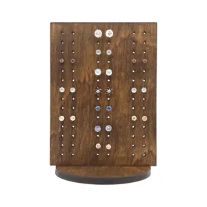 Dettaglio del supporto per orecchini in legno, organizzatore di gioielli rustico con fessure.
