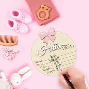 Gros plan sur la plaque en bois d'annonce de naissance avec accessoire jalon Hello World.