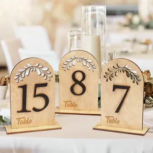 Rustic wooden wedding table numbers with arch leaf hollow design, perfect for event decor.