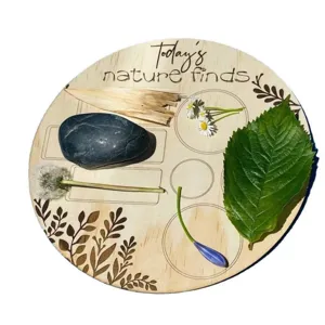 Detail de plateau de collecte de nature en bois avec motifs graves pour les enfants.