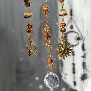 Crystal suncatcher detail view with amber beads, golden star and sun pendants, clear prism.