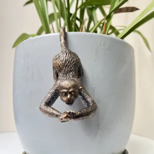 Primo piano dettagliato di un ornamento di scimmia in resina per vasi di fiori e piante.
