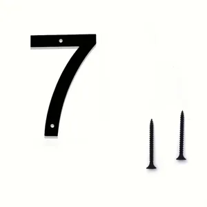 Primer plano del número de casa moderno de metal negro 7 con tornillos de fijación a juego.
