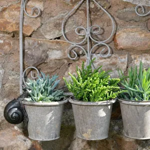 Wall hanging snail planter detail, resin animal sculpture with flower pot for outdoor garden decor.